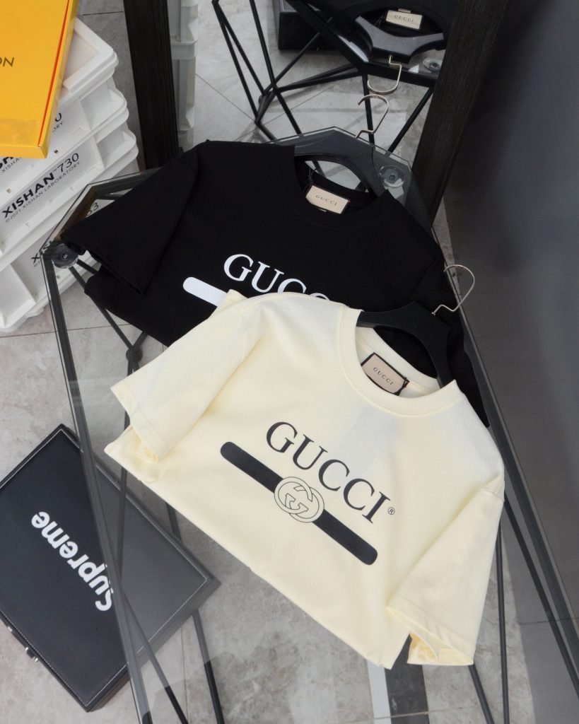 Gucci（グッチ） コピー 芸能人  ベルトロゴダブルgテーププリントラウンドネック半袖Tシャツ